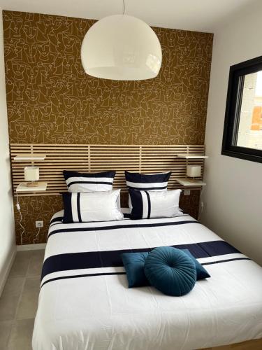 sypialnia z dużym łóżkiem i niebieskimi poduszkami w obiekcie Appartement centre de Roanne 38m2 w mieście Roanne