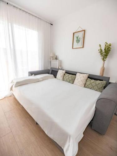 uma grande cama branca num quarto com um sofá em Studio / 900m de la plage em Fréjus