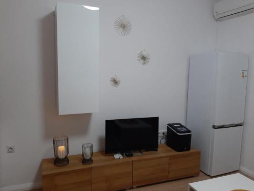 ein Wohnzimmer mit einem TV auf einem Holzschrank in der Unterkunft Apartman-Kuzminski-Kraje14 in Vodice