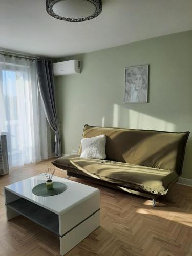 een woonkamer met een bank en een salontafel bij Visinskio apartamentai in Šiauliai