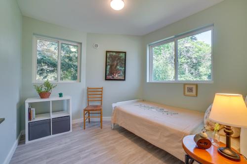 a bedroom with a bed and a desk and two windows at Bellevue Abode Balcony, 13 Mi to Downtown Seattle in Bellevue