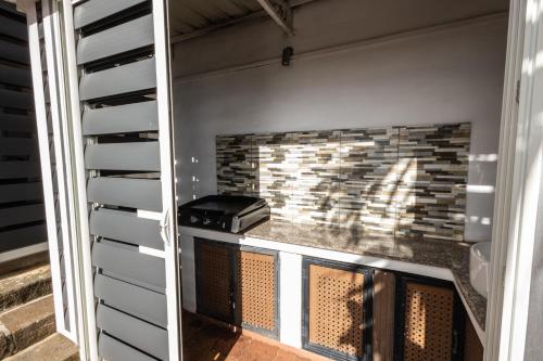 a brick fireplace in a garage with a grill at Les Villas 33 in Baie du Tombeau