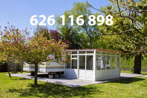 a small building in a park with a clock on it at Xilloi Playa in O Vicedo