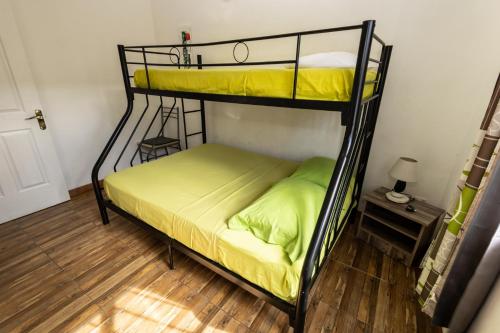 a bedroom with two bunk beds with yellow sheets at Les Villas 33 in Baie du Tombeau