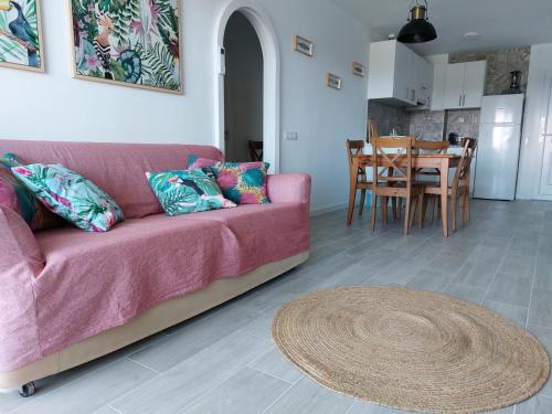 a living room with a pink couch and a table at Family Relax Apartment in Alcudia