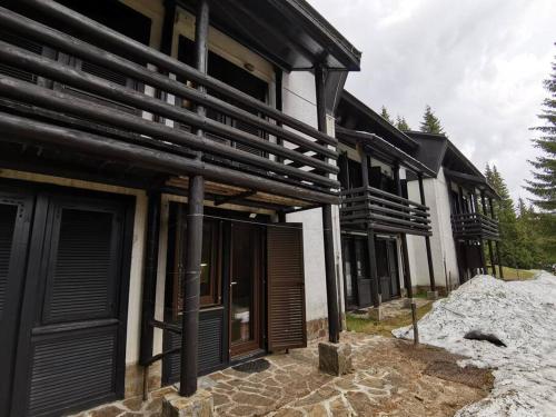 a building with black shutters on the side of it at Pocket apartment Rogla - Gaber 121 in Zreče