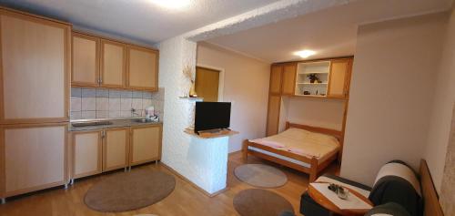 een kleine kamer met een keuken met een bureau en een televisie bij D&A Apartment in Ohrid