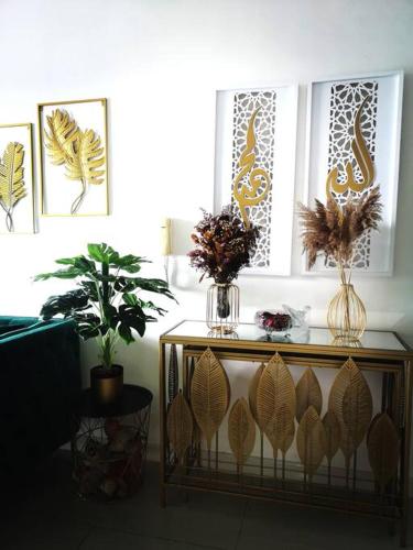 a living room with a table with vases and plants at The Sarang - Another Space On Earth! in Kampong Tangkas