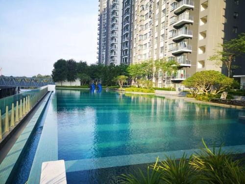 a river in a city with tall buildings at The Sarang - Another Space On Earth! in Kampong Tangkas