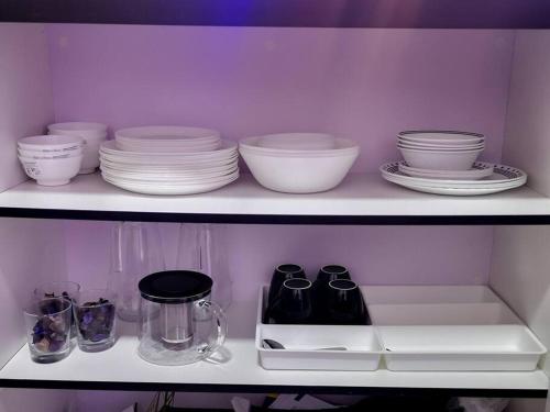 a shelf with plates and bowls and other dishes at The Sarang - Another Space On Earth! in Kampong Tangkas