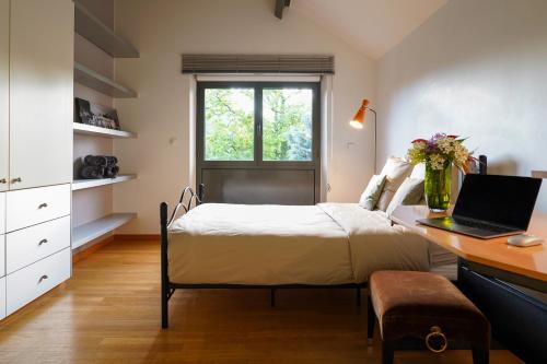 奧賽的住宿－Maison contemporaine au coeur de Paris-Saclay，一间卧室配有一张床和一张带笔记本电脑的书桌