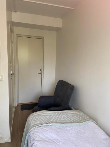 uma cadeira ao lado de uma cama num quarto em Liten koselig hybel i Gamle Oslo em Oslo