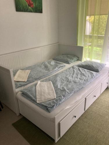uma cama branca com duas almofadas em cima em Éva apartman em Balatonboglár