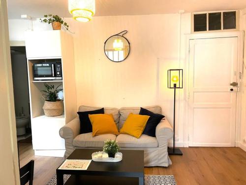 a living room with a couch with yellow pillows at Appartement calme et cosy in Pau