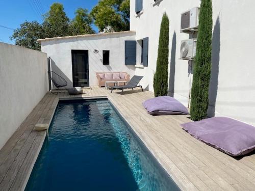 - une piscine avec des oreillers violets à côté d'une maison dans l'établissement La maison de Suzy, à Saint-Rémy-de-Provence