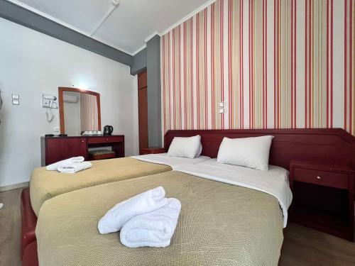 een hotelkamer met 2 bedden en handdoeken erop bij Hotel Lido in Athene