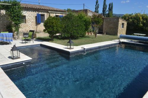 una piscina in un cortile con una casa di Château Saint-Pierre de Mejans a Puyvert