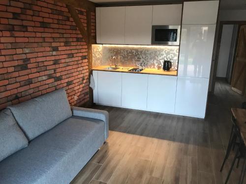 a living room with a couch and a kitchen at Apartamenty MOGADOR in Szczytna