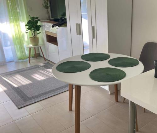 uma mesa branca com círculos verdes numa cozinha em Éva apartman em Balatonboglár