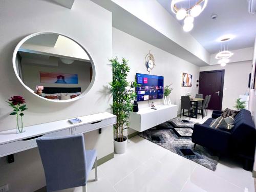 sala de estar con espejo en la pared en New & Modern Cozy 1BR w/ Balcony@BGC, WiFi 300MBPS, en Manila