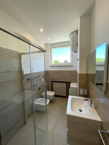 a bathroom with a shower and a sink and a toilet at Caprice 2.0 in Peschiera del Garda