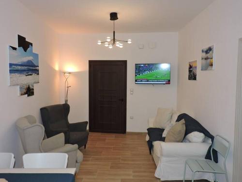 a living room with two couches and a tv at Annissa Appartment in Karpathos