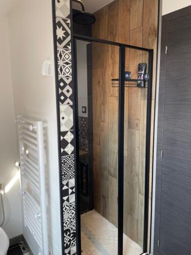 a shower with a glass door in a bathroom at appartement des mésanges 