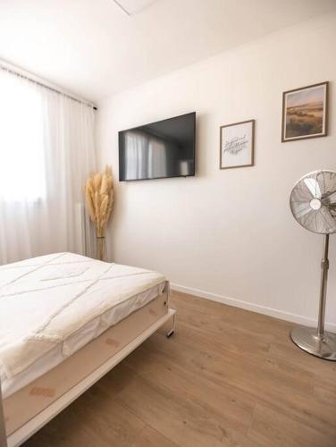 une chambre avec un lit et une télévision à écran plat dans l'établissement Studio / 15min de la plage, à Fréjus