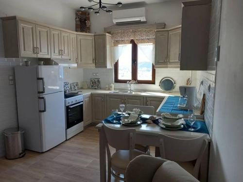 a kitchen with a table and a white refrigerator at Annissa Appartment in Karpathos