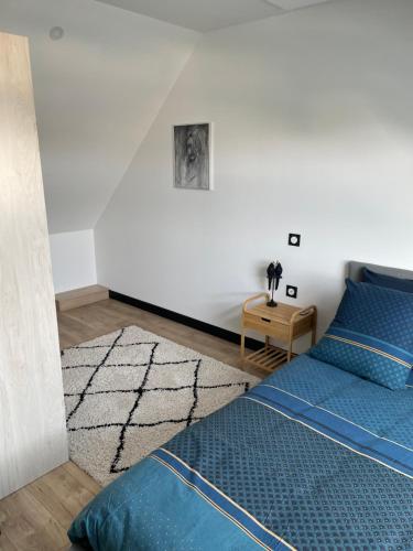 a bedroom with a blue bed and a white wall at appartement des mésanges 