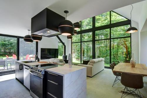 a kitchen and living room with a table and chairs at Nature's Paradis Chalets by Rcnt Chalets in Lac-Superieur