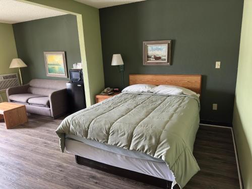a bedroom with a large bed and a couch at Harbor Lights Lodge in Kewaunee