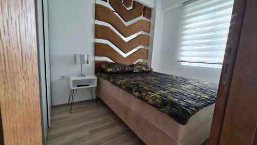 a small bed in a room with a wall at RELAX LUX AKVA PARK(K-KOMPLEX) in Jagodina