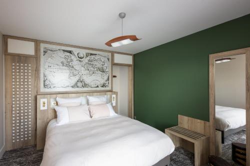 カマレ・シュル・メールにあるRésidence Bellevueの緑の壁のベッドルーム1室(白いベッド1台付)