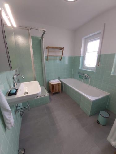 a bathroom with a bath tub and a sink at Hubis Ferienwohnung in Olpe