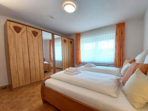 um quarto com uma cama grande e uma janela em Hubis Ferienwohnung em Olpe