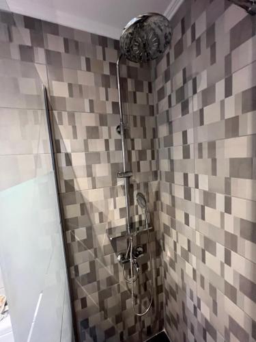 a shower in a bathroom with a tiled wall at John's apartment's near Athens Airport!! in Spáta