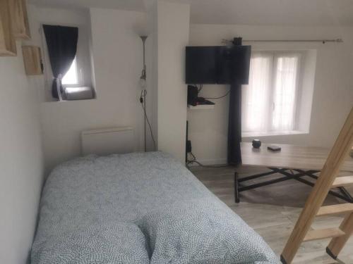 une chambre avec un lit, une table et une télévision dans l'établissement Little House : CDG-Paris-Asterix, à Louvres