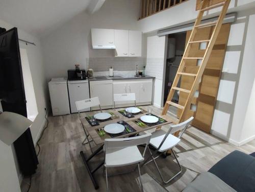 une cuisine avec une table, des chaises et une échelle dans l'établissement Little House : CDG-Paris-Asterix, à Louvres