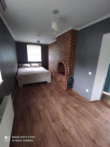 a bedroom with a bed and a brick fireplace at Casa Maria in Pohrebea