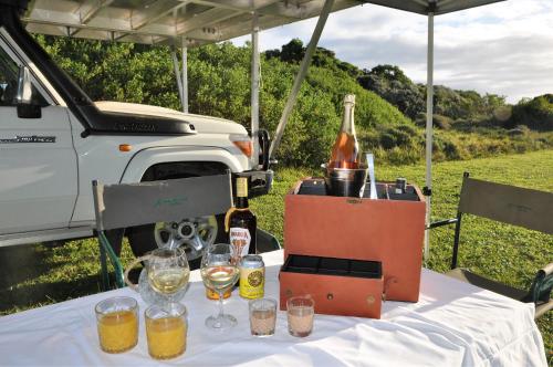 a table with a bottle of wine and glasses on it at Dream Cruiser in Addo with Private Bath in Kirkwood