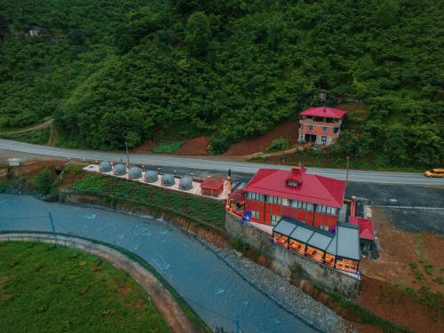 un edificio con techo rojo junto a un río en Lidzo Villa Butik Otel en Trebisonda