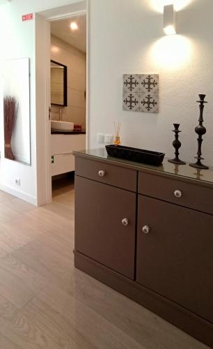 a bathroom with a dresser with a sink on it at Apart Great Sea View in Alvor