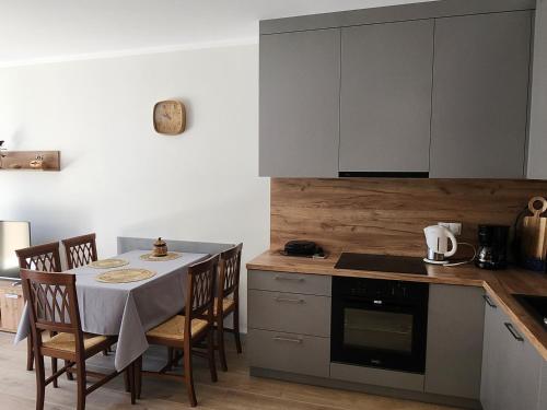 a kitchen with a table with chairs and a stove at Dwa Jelonki, ul Ściegiennego, centrum, garaż, ogródek in Kielce