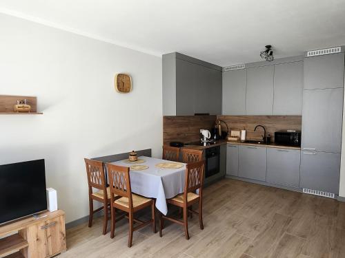 eine Küche mit einem Tisch und Stühlen sowie einem TV in der Unterkunft Dwa Jelonki, ul Ściegiennego, centrum, garaż, ogródek in Kielce
