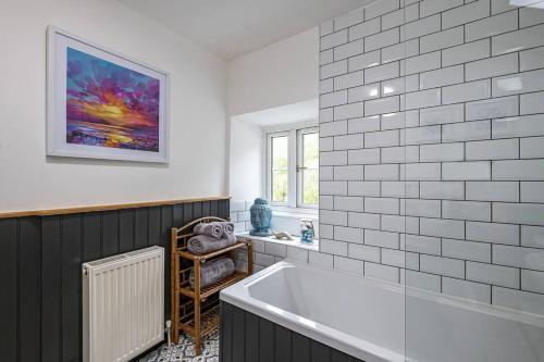 baño con bañera blanca y ventana en Hawddamor, en Dolgellau