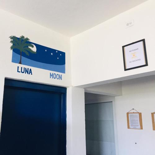 a blue door in a room with a sign that reads luna mom at Vive Alegria Hostel in Puerto Vallarta