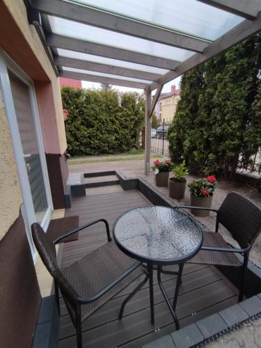 a patio with a table and chairs on a deck at Apartament Joanna in Międzyzdroje