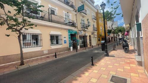 a city street with buildings and a motorcycle parked on the street at Hotel Boutique Andalucia in Fuengirola