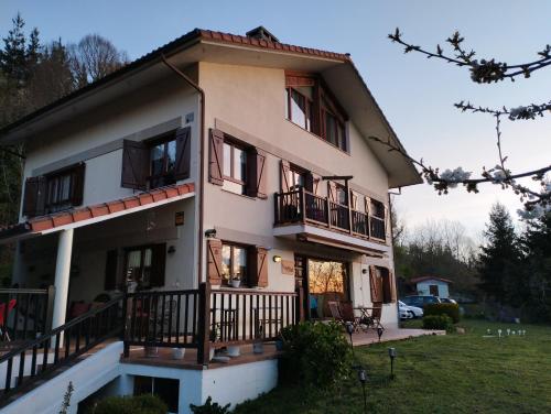 Una casa grande con balcones en un lateral. en B&B Eguzkitza, en Elgeta